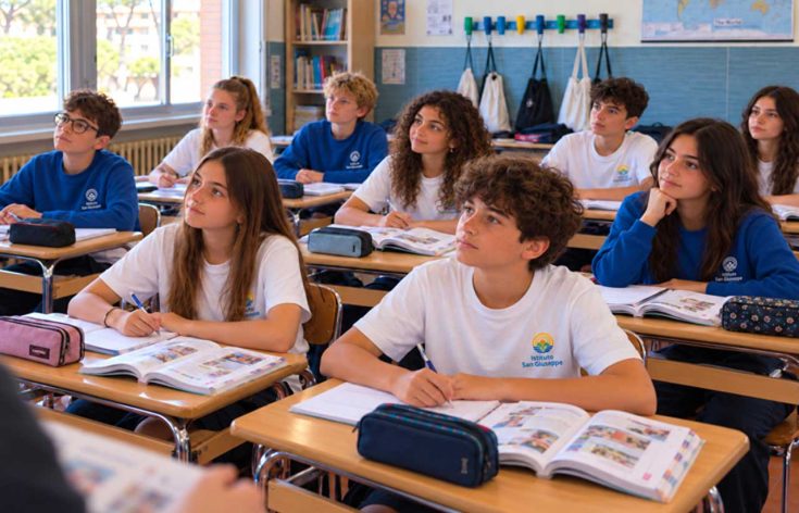 Studenti della scuola secondaria di primo grado seguono l’insegnante con i libri aperti sui banchi